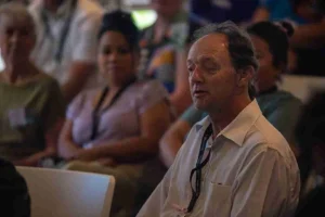 A man sitting in a room with a group of people
