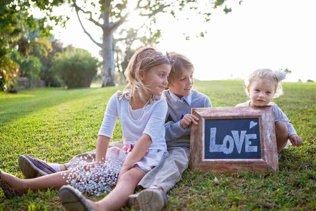 Three children sitting on grass