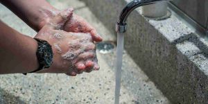 person washing their hands under running tap