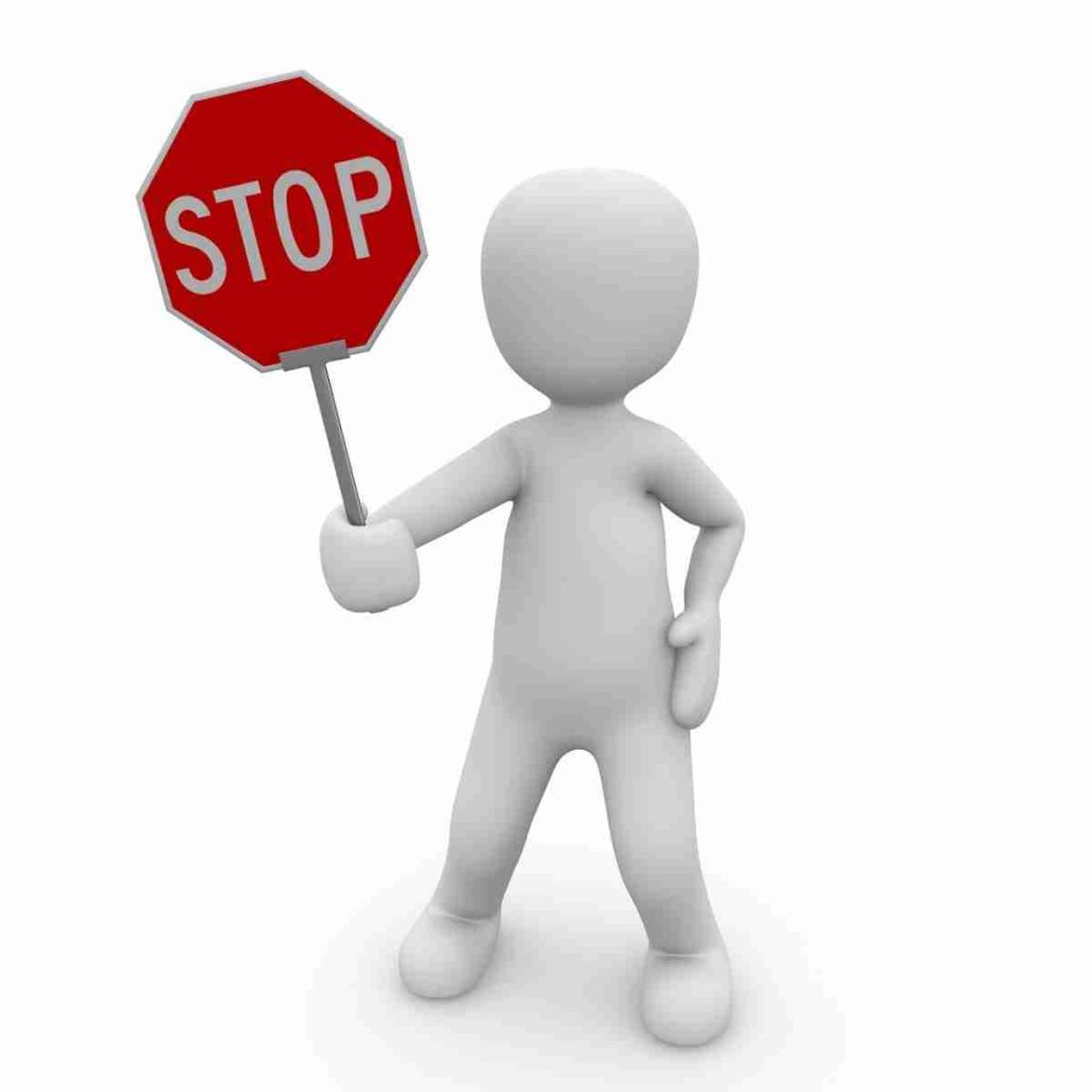 White clay-style person holding a stop sign