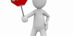 White clay-style person holding a stop sign