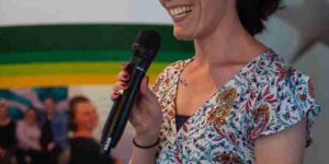 Person presenting in front of a sign that says Inclusion Australia