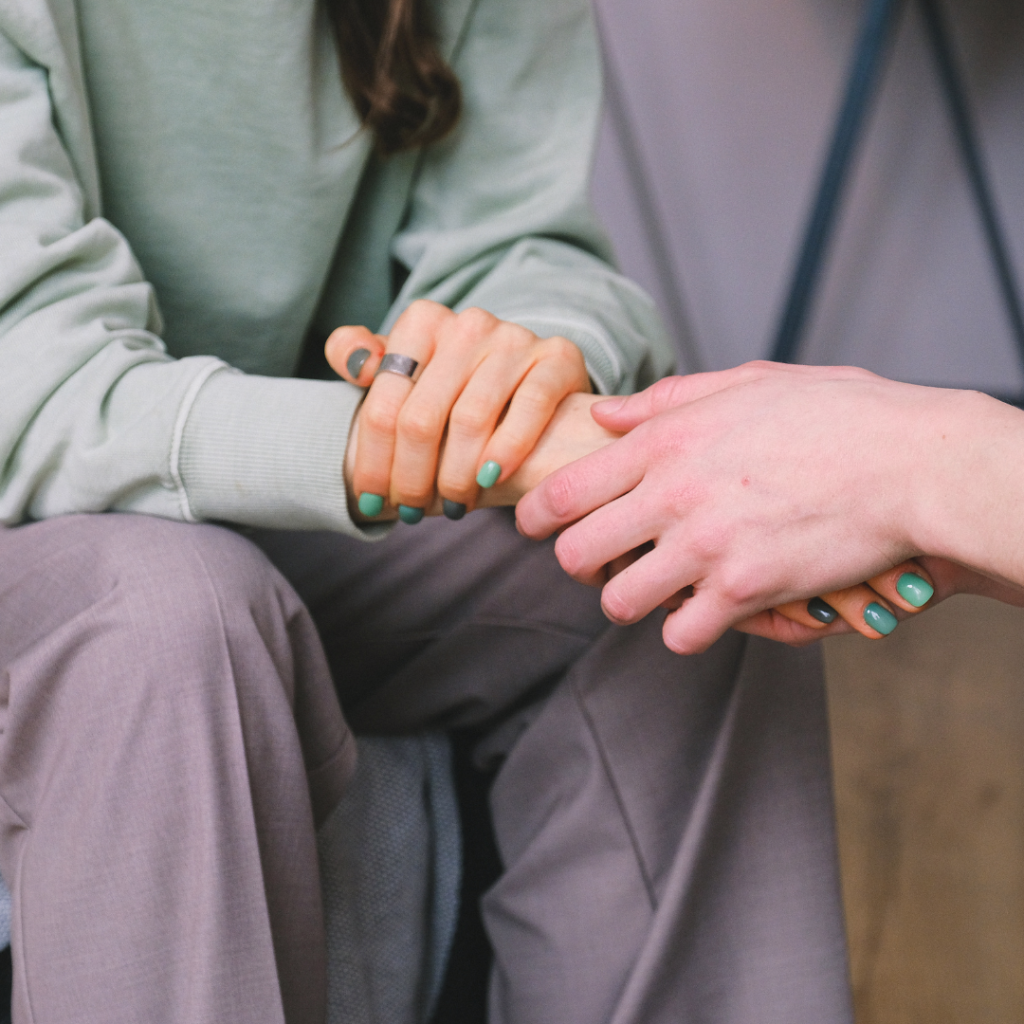 Image of two people holding hands.