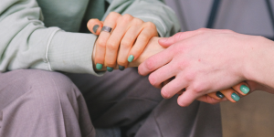 Image of two people holding hands.