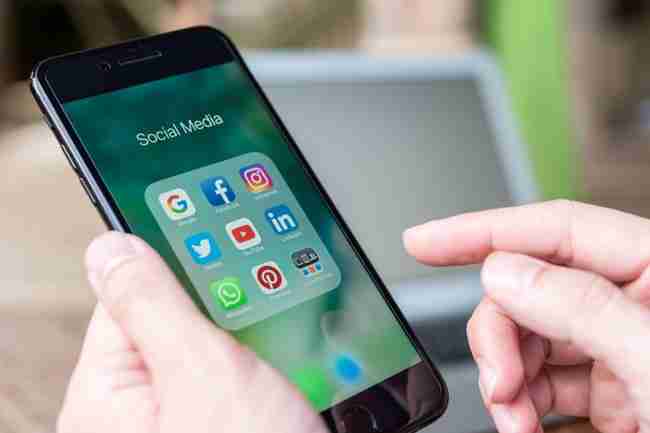 A phone open with several social media app icons on the screen.