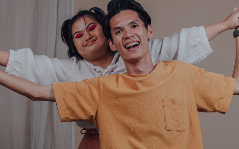 A boy and girl smiling with their arms stretched out