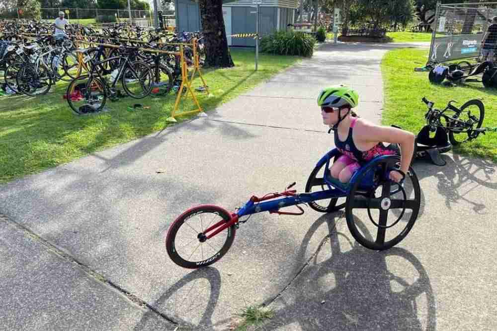 A woman who has an amputation wearing a helmet riding a modified bike