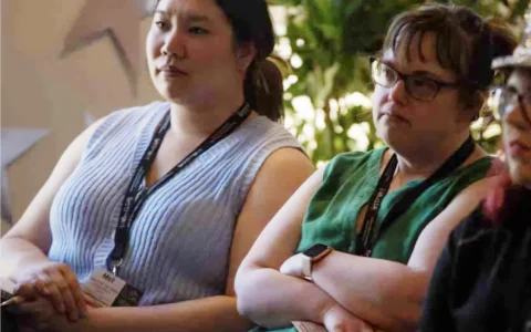 Two people sitting and listening to a presentation