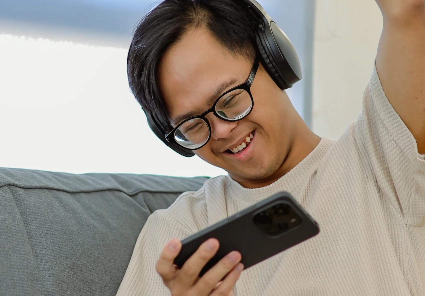 A guy looking at his phone smiling