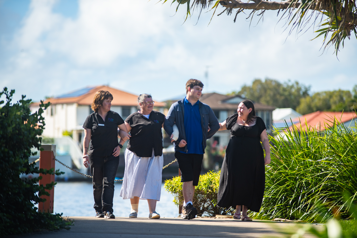 four people walking outside in a suburban street
